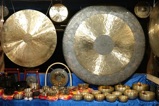 Des gongs suspendus à l’arrière plan et des bols chantant posés devant.