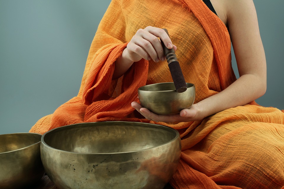 Pratiquant de méditation utilisant un bol chantant 
